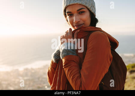 Porträt der jungen afrikanischen Frau tragen warme Kleidung stehen auf Klippe auf der Wintertag. Weibchen auf der Wanderung in der Natur. Stockfoto