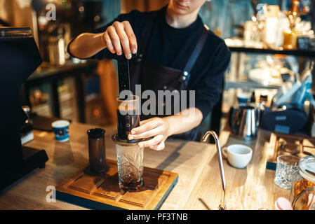 Junge männliche Barista macht frischen Espresso, Kaffee schwarz Vorbereitung im Cafe. Barkeeper arbeiten in der Cafeteria, barmixer Besetzung Stockfoto