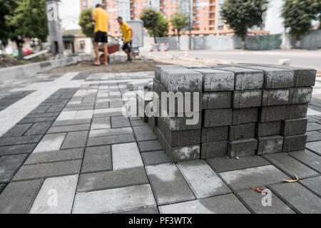 Bürgersteig Kopfsteinpflaster in den Stapel auf der Straße. Beton oder Granit grau square Gehwegplatten für bürgersteig Bau. Industrie Herstellung oder Gebäude Konzept. Baumaterial Stockfoto
