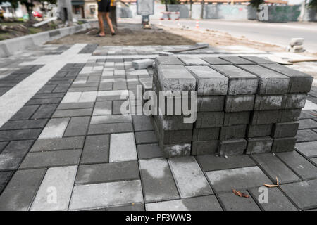 Bürgersteig Kopfsteinpflaster in den Stapel auf der Straße. Beton oder Granit grau square Gehwegplatten für bürgersteig Bau. Industrie Herstellung oder Gebäude Konzept. Baumaterial Stockfoto