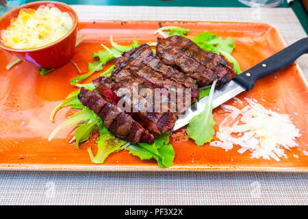Traditionelle italienische Tagliata Steak mit Parmesankäse und Salat als Close-up auf einer Platte Stockfoto