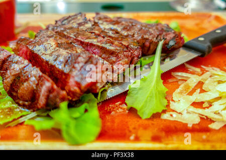 Traditionelle italienische Tagliata Steak mit Parmesankäse und Salat als Close-up auf einer Platte Stockfoto