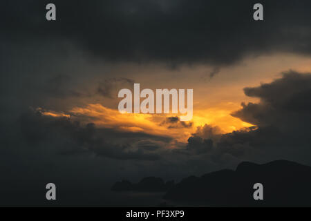 Dunkle dramatische Himmel während Goldgelb Sonnenuntergang auf exotische Inseln, Thailand Stockfoto