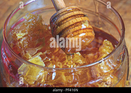 Kamm Honig in einem Glas Schüssel auf Holz- Hintergrund Stockfoto