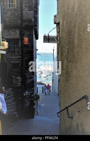 Tenby, Pembrokehsire, South Wales, UK. Juli 26, 2018. Urlauber, die die historischen Kai Hügel von Bridge Street an der High Street in Tenby Stockfoto