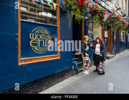 Zwei Frauen vor einem Eintritt in der Welt Ende Pub in Edinburghs Royal Mile zu plaudern. Diese historischen Pub wurde in der ehemaligen 16. Jahrhundert Stadt gebaut Stockfoto