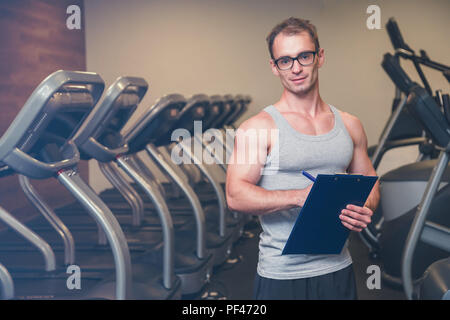 Frau, trainieren Sie im Fitnessraum mit ihrem persönlichen trainer Stockfoto