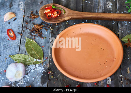 Leeren Teller und frische red hot chili Pfeffer, Gewürze und Löffel auf Holz rustikale Hintergrund, Ansicht von oben Stockfoto