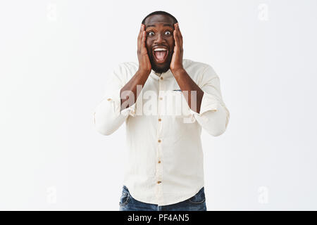 Kann nicht glauben, ich bin Richman. Portrait von begeistert erstaunt good-looking Happy dunkelhäutiger Mann mit kurzen Haarschnitt, schreiend aus Überraschung und positive Emotionen, Gefühl freudiger, Palmen an den Backen Stockfoto