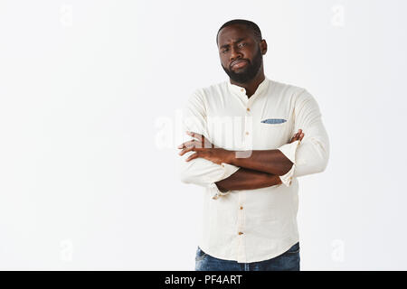 Sehr verdächtig aussehende, Zweifel. Portrait von intensiven Zögern afrikanischer amerikanischer Mann in Weiß Shirt,, Hände auf Brust verschränkt und starrte mit Unglauben an der Kamera, in Sorge Stockfoto