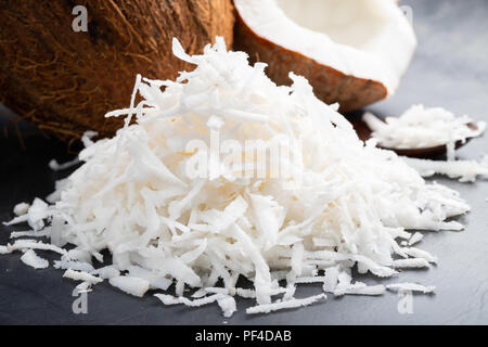 Frische Kokosnuss Flocken auf schwarzem Hintergrund. Stockfoto