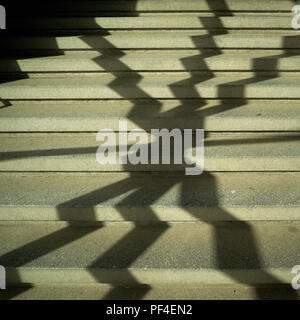 Schatten eines Fenster Gitter auf den Stufen einer Treppe Stockfoto