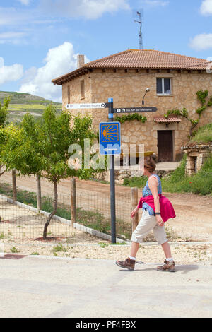 Pilgerfrau, die in die Stadt Castrojeriz Spanien geht, während sie auf dem Jakobsweg den Jakobsweg entlang geht Stockfoto