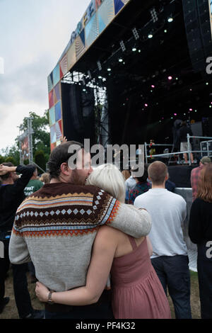 Glanusk Park, Brecon, Wales, 18. August 2018. Tag 2 des Green man Musikfestivals in den Brecon Beacons Mountains in Wales. Ein junges Paar umarmt sich vor der Menge auf der Hauptbühne der Berge. Quelle: Rob Watkins/Alamy Live News Stockfoto