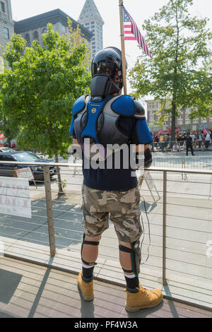 Seattle, WA, USA. 18 August, 2018. Ein pro Waffe Unterstützer in einem Schutzausrüstung holdig eine amerikanische Flagge auf counterprotesters kreischend auf der anderen Seite der Straße. Bei den pro Waffe Kundgebung an der City Hall Plaza. Credit: Maria S./Alamy Leben Nachrichten. Stockfoto