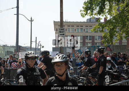 Seattle, WA, USA. 18 August, 2018. Eine weibliche Anti gun Unterstützer stehen auf einem Podest auf Th pro Waffe Anhänger auf der Straße marschieren. Credit: Maria S./Alamy Leben Nachrichten. Stockfoto
