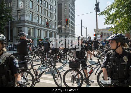 Seattle, WA, USA. August 2018. Polizeibeamte sichern die Straße, auf der die Demonstranten des rechten und linken Flügels in der Nähe des Seattle City Hall gegenüberstehen. Quelle: Maria S./Alamy Live News. Stockfoto