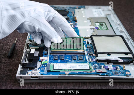 Nahaufnahme makro Pinsel arbeiten Reinigung der gebrochenen Laptop. Zerlegt moderne Ultrabook ohne interne DDR4 Speicher. Die Menge an RAM, Erhöhung der Stockfoto