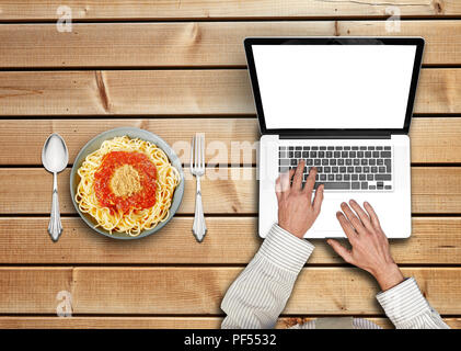 Geschäftsmanns, der auf seinem Laptop bestellen Pasta zum Mittagessen Stockfoto