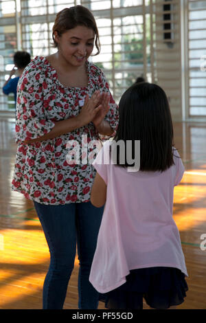 Cpl. Melissa Perez, eine Versorgung administration Sekretärin bekämpfen Logistik Bataillon 31, 31 Marine Expeditionary Unit, spielt ein Spiel mit einem lokalen Kind an Namisato Community Center, Okinawa, Japan, August 9, 2018. Community Relations Veranstaltungen geben 31. MEU Marines eine Gelegenheit, um die Beziehungen zu den Nachbarn aufzubauen und einen Beitrag zu den Gemeinschaften um Marine Corps Installationen. (U.S. Marine Corps Foto von Lance Cpl. Amy Phan/Freigegeben) Stockfoto