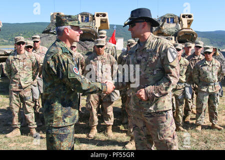 Us-Armee Kapitän Nicholas Spicocchi, Kommandeur der Alpha Company, 2nd Battalion, 5th Cavalry Regiment, 1st Armored Brigade Combat Team, 1.Kavallerie Division, gibt Bulgarische Col. Stojan Georgiev Schopow, 2. mechanisierten Brigade Stabschef, eine Münze als Zeichen der Anerkennung bei der Abschlussfeier der Übung Platin Löwe, eine jährliche Übung, fördert die regionale Stabilität und baut dauerhafte Beziehungen mit Partnerstaaten, bei der Abschlussfeier, Novo Selo, Bulgarien, 9. August 2018. Diese Übung ist zur Unterstützung der Atlantischen lösen, ein bleibendes Training bet Stockfoto