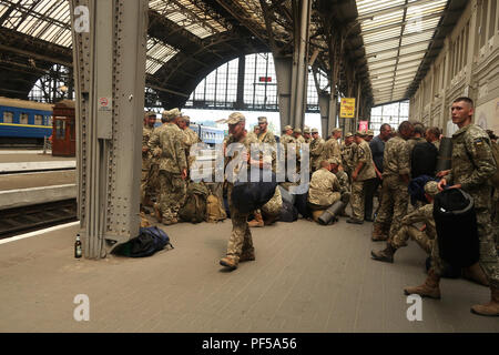 Eine Gruppe von ukrainischen Soldaten auf dem Weg zu ihrer Basis auf dem Bahnsteig von Lviv-Holovnyi Bahnhof in der Stadt Lviv, Ukraine Stockfoto