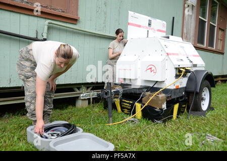 Us Air Force Staff Sgt. Mary Beth Thomas (links), ein IT-Techniker 158 Fighter Wing, Vermont Air National Guard und US Air Force Staff Sgt zugeordnet. Caitlin Lee (rechts), ein Client Systeme Techniker 158 Fighter Wing, Vermont Air National Guard zugewiesen, ein Generator während Tropic Care Maui County 2018 bei Hana Hi. 15 August, 2018. Tropic Care Maui County 2018 ist eine gemeinsame, "hands-on"-Readiness Training Mission, die keine Kosten für medizinische, zahnmedizinische und Vision Dienstleistungen für die Menschen an sechs Standorten in Maui, Molokai und Lanai von August 11-19. (U.S. Stockfoto