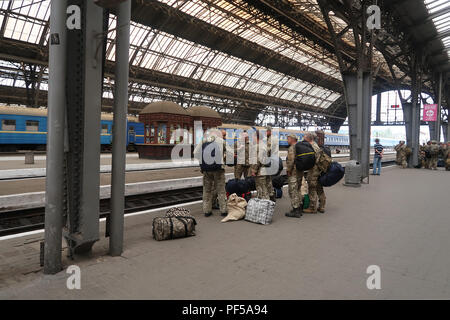 Eine Gruppe von ukrainischen Soldaten auf dem Weg zu ihrer Basis auf dem Bahnsteig von Lviv-Holovnyi Bahnhof in der Stadt Lviv, Ukraine Stockfoto