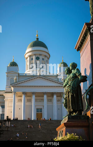 Kathedrale von Helsinki, Ansicht der lutherischen Kathedrale und Statuen der Nordischen Frauen stationiert auf der Alexander ll Monument, das sich in den Senatsplatz in Helsinki, Finnland. Stockfoto