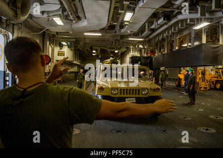 Cpl. Dominick Fattig, ein Inventory Specialist bei Bekämpfung der Logistik Bataillon 31, Masse führt ein Humvee an Bord der USS Wasp (LHD-1) am weißen Strand Marinestützpunkt, Okinawa, Japan, August 16, 2018. Fattig, ein Eingeborener von Saint Joseph, Missouri graduierte von der Central High School im Jahr 2015; er wird in 2015 Soldaten von der Einstellung von sub-Bahnhof Saint Joseph. Die 31. MEU Marinesoldaten und Matrosen an Bord startete die US Navy Schiffe der Wasp Amphibious Ready Gruppe für Herbst Patrol 2018 mit Combat Logistik Bataillon 31; Marine Medium Tiltrotor Squadron 262 (Verstärkt); Bataillon Bataillon Landung Team, 2., 5. Stockfoto