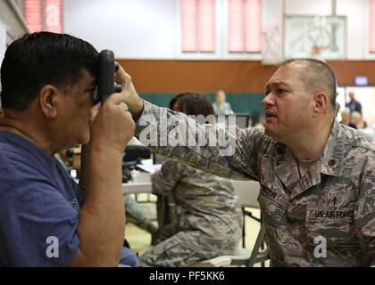 Us Air Force Maj. Derek Melton, ein Optiker die 181St Medical Group, Indiana Air National Guard zugewiesen, führt eine Augenuntersuchung auf einen Patienten Aug.11, 2018 in Lanai City, HI. Tropic Care Maui County 2018 bietet medizinische Service Mitglieder- und Supportpersonal in "hands-on"-Readiness Training für zukünftige Bereitstellungen zu, während für direkte und dauerhafte Vorteile für die Bevölkerung von Maui, Molokai und Lanai, August 11-19 vorbereiten. (U.S. Air National Guard Foto von Airman First Class Mckenzie Airhart) Stockfoto