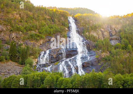 Schönen Wasserfall in die Berge bei Sonnenuntergang leuchten, Norwegen