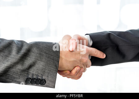 Zwei Geschäftsleute die Hände schütteln über ein unscharfes Abstrakt Hintergrund konzeptionelle von einem Abkommen, Abkommen, Partner oder Gruß. Stockfoto