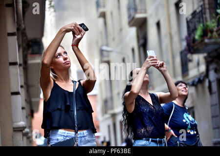 Junge Frauen, die Fotos auf ihren Smartphones, Gracia, Barcelona. Stockfoto