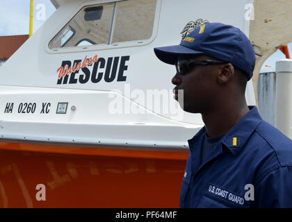 Fähnrich Myles Durr, der stellvertretende Generaldirektor der Coast Guard Cutter Oliver Berry (WPC 1124), steht vor einem Hawaii County Feuerwehr Boot an ein Asset open house in Hilo, Hawaii, Nov. 14, 2018. Die Oliver Berry wurde in Hilo in einer gemeinsamen Suche und Rettung Übung teilzunehmen. (U.S. Coast Guard Foto von Petty Officer 3. Klasse Matthew West/Freigegeben) Stockfoto