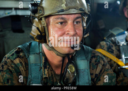 Master Sgt. Gabriel Machado bereitet sich auf den Start beim Fallschirm- und Luftzufuhr Training Operations Aug 14, 2018 at Ie Shima, Okinawa, Japan. Machado diente, wie der Assistent jumpmaster während der Ausbildung, in Kontakt mit der Crew in der CH-53E Super Stallion Hubschrauber, während die Weiterleitung von Informationen an die jumpmaster. Das Training bestand aus Low-level-statische Linie und militärischen freien Fall springt auf 10.000 Fuß um die Marines beherrschen als Fallschirm rigger/Air Delivery Spezialisten zu halten. Machado, ein Eingeborener von New York, New York, ist die Luft, die Lieferung Chief mit Landung-Support Stockfoto