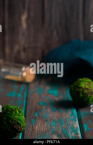 Alchemie Gold im Glas kleine Flasche. Moss-Kugeln und rustikalen Holzmöbeln, Schreibtisch. Magie und Hexerei Konzept. Stockfoto