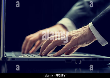 In der Nähe von Low Angle View eines Geschäftsmannes Texteingabe auf einem Laptop in der Dunkelheit konzeptionelle eines engagierten Mitarbeiter zu spät oder eines Hackers steali Stockfoto