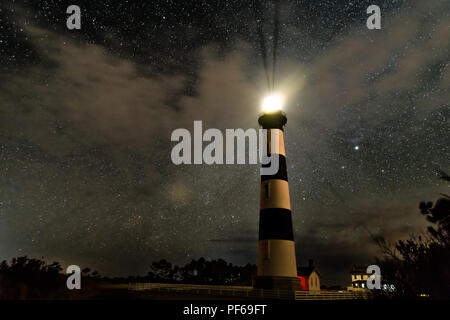 Leuchtturm auf die Outer Banks hell leuchtend in der Nacht vor der Wolken und einen sehr grossen Himmel voller Sterne und die Milchstraße Stockfoto