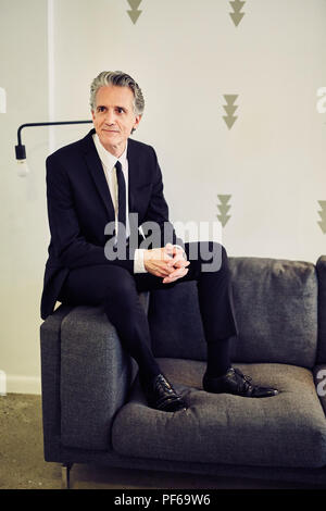 Grauhaariger Business Mann trägt einen schwarzen Anzug im Innenbereich Stockfoto