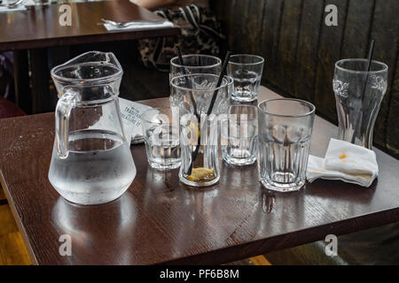 Leere Gläser und einen Krug Wasser auf einen Tisch im Restaurant. Stockfoto