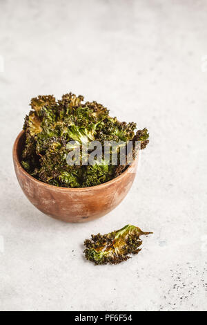 Kale Chips in eine hölzerne Schüssel auf weißem Hintergrund. Saubere Konzept essen. Vegan leben! Stockfoto