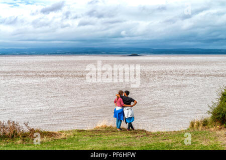 Ein paar auf Battery Point, Portishead in der Nähe von Bristol, England, Großbritannien mit Blick auf den Severn Estuary mit Wales über umfassen. Stockfoto