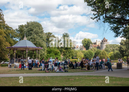 Eine Band spielt ein kostenloses Konzert in der Band stand in Alexandra Gärten in Windsor, UK. Die Leute sitzen auf Klappstühlen, benchses und der Boden zu beobachten. Stockfoto