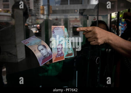 Caracas, Venezuela. 20 Aug, 2018. Neue Banknoten halten Sie sich an die Eingangstür einer Bank. Mit einer ganzen Reihe von Reformen, die venezolanische Regierung will die schwere wirtschaftliche Krise des Landes zu lösen. Angesichts der Hyperinflation, fünf Nullen haben von der nationalen Währung entfernt wurde. Eine Million Bolívar fuerte (starke Bolívar) wurde 10 Bolívar soberano (souveräne Bolívar). Darüber hinaus ist die Bolívar ist der neuen crypto Währung Petro verknüpft werden. Credit: Rayner Pena/dpa/Alamy leben Nachrichten Stockfoto