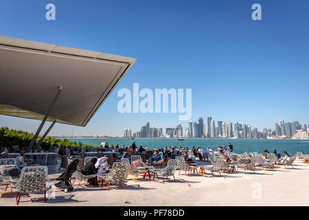 Doha, Katar - Jan 8 2018 - Einheimische und Touristen, eine Cafe Bar mit Doha Skyline im Hintergrund in einem blauen Himmel Tag, Doha in Katar Stockfoto