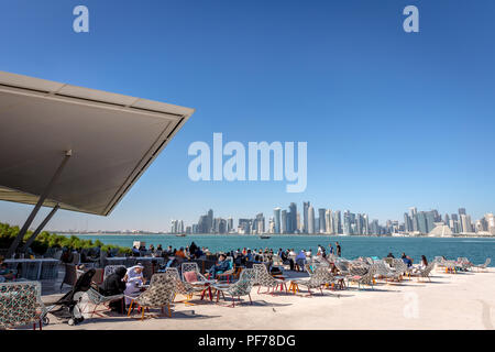 Doha, Katar - Jan 8 2018 - Einheimische und Touristen, eine Cafe Bar mit Doha Skyline im Hintergrund in einem blauen Himmel Tag, Doha in Katar Stockfoto