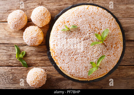 Große und Kleine tropezienne Kuchen mit zarte Creme mit Perle Zucker und Minze in der Nähe eingerichtet - auf den Tisch. Horizontal oben Ansicht von oben Stockfoto