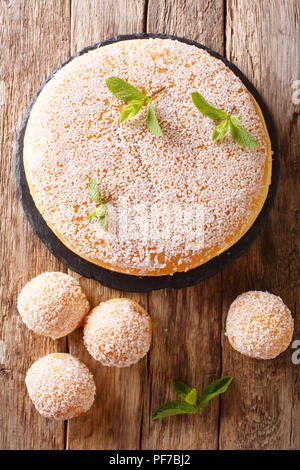 Große und Kleine tropezienne Kuchen mit zarte Creme mit Perle Zucker und Minze in der Nähe eingerichtet - auf den Tisch. Vertikal oben Ansicht von oben Stockfoto