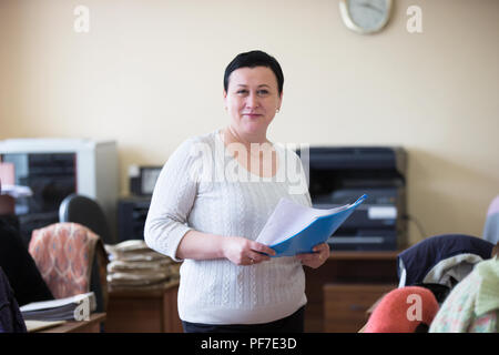 Belarus, Gomel, 25. April 2018. Das Büro ist zentral. russische Bürokratie. Frau Büroangestellter mit Papieren Stockfoto